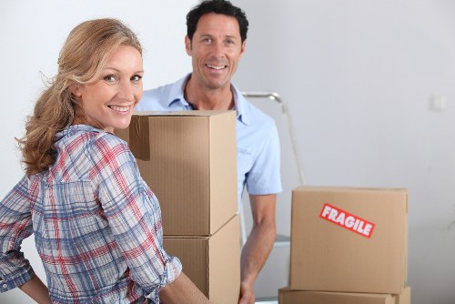 Movers protecting floors and carrying items carefully through a property